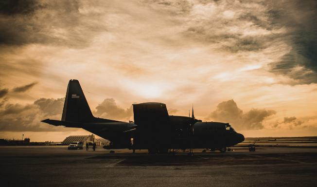 Jet on runway in front of sunset