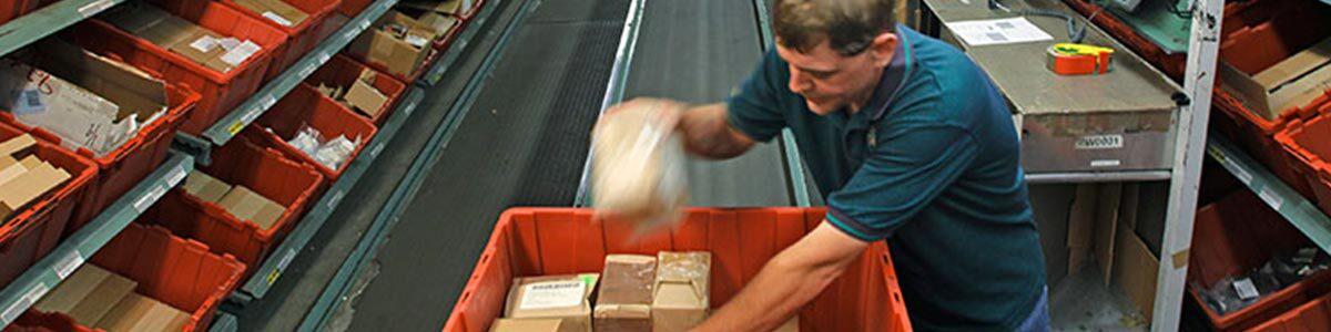 man packages materials in factory