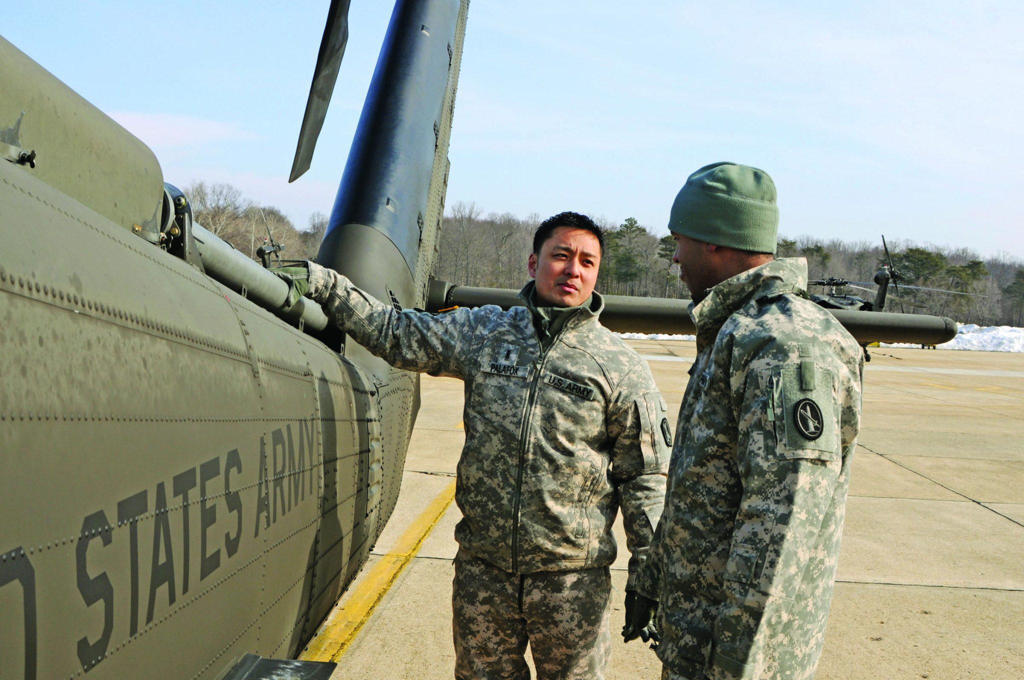 soldiers talk outside helicopter