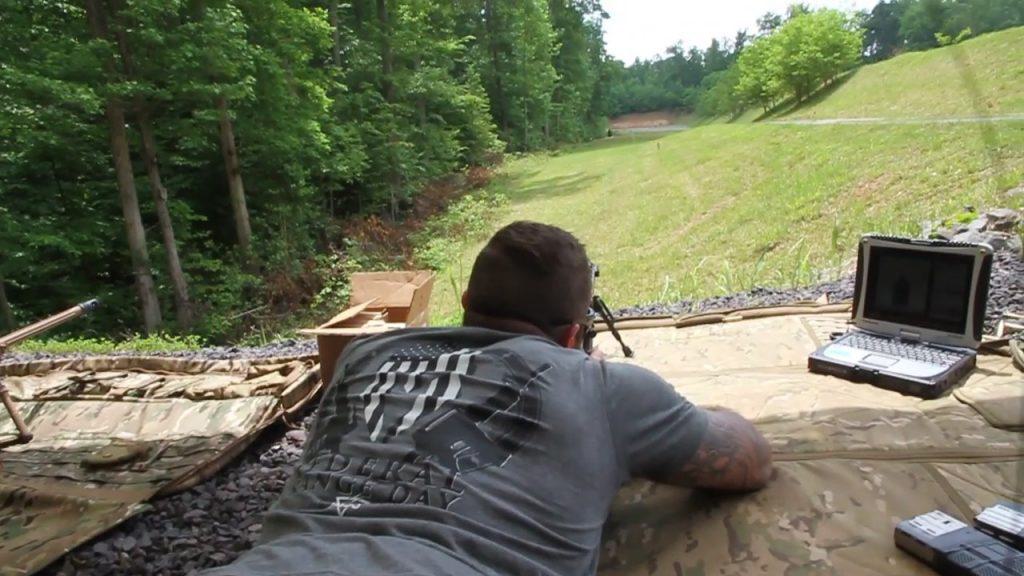 man laying down looks through scope