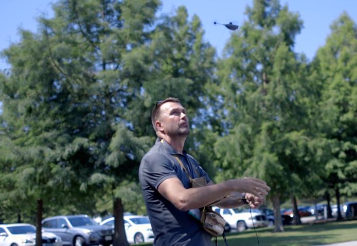 man flies small drone